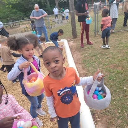 Children holding baskets with eggs outdoors