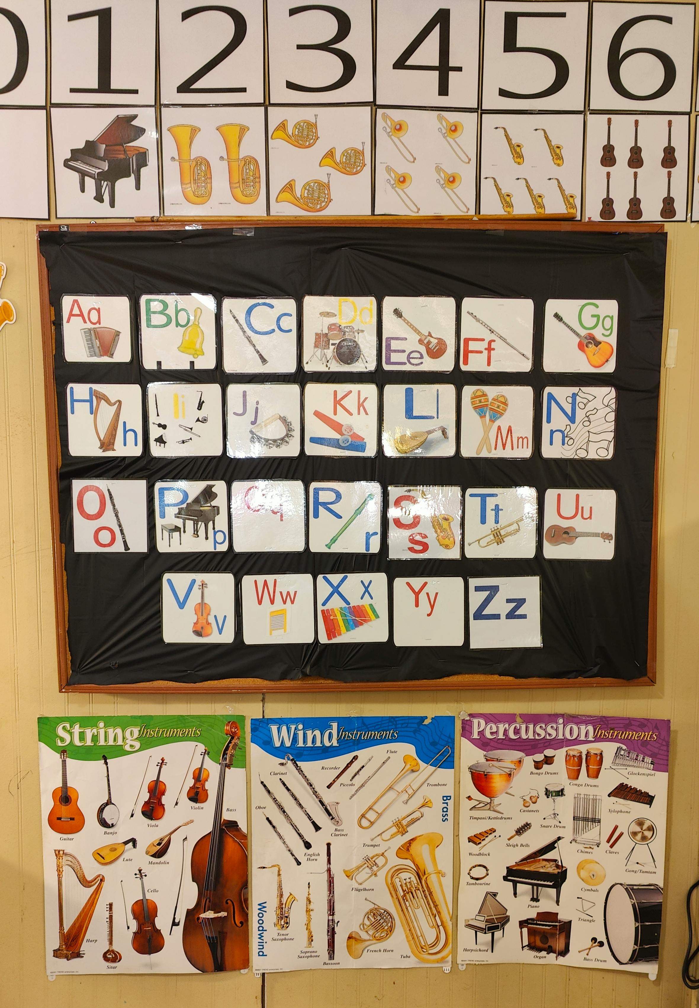 Classroom wall with number cards, alphabet cards with musical instruments, and instrument posters