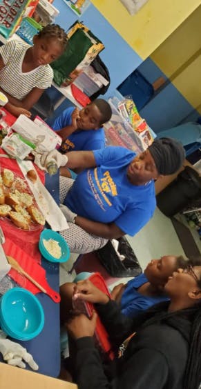 Adult and children preparing food at a table
