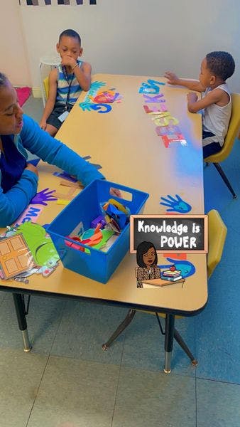 Person and two children at a table with learning materials