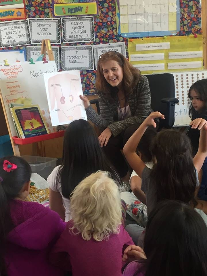 Person showing children a drawing in a classroom