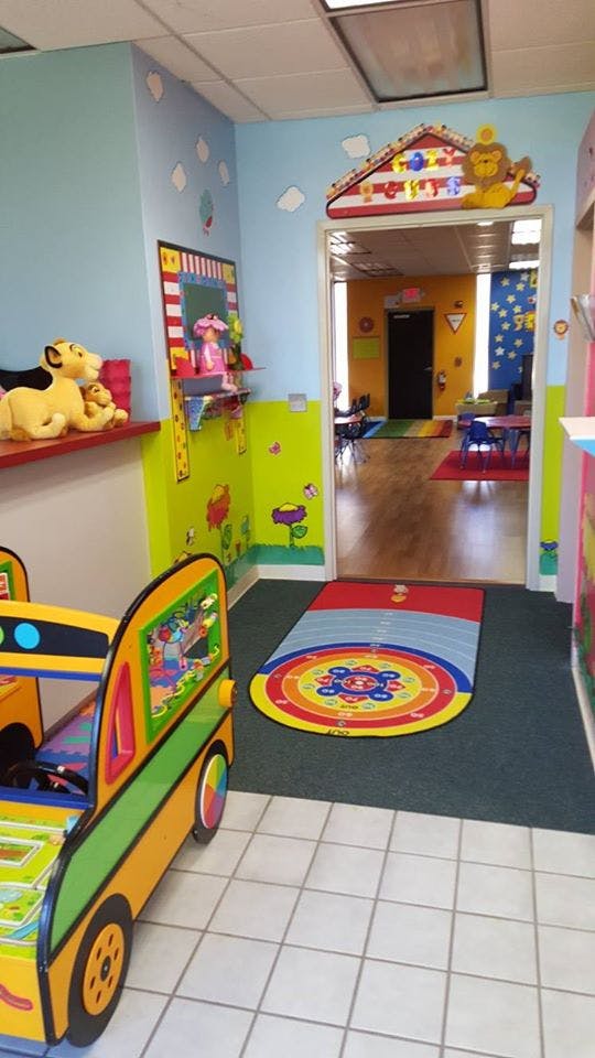 Playroom with colorful walls, toys, and a child-sized car