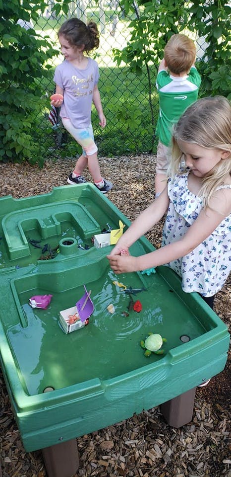 Children playing with a water table outdoors