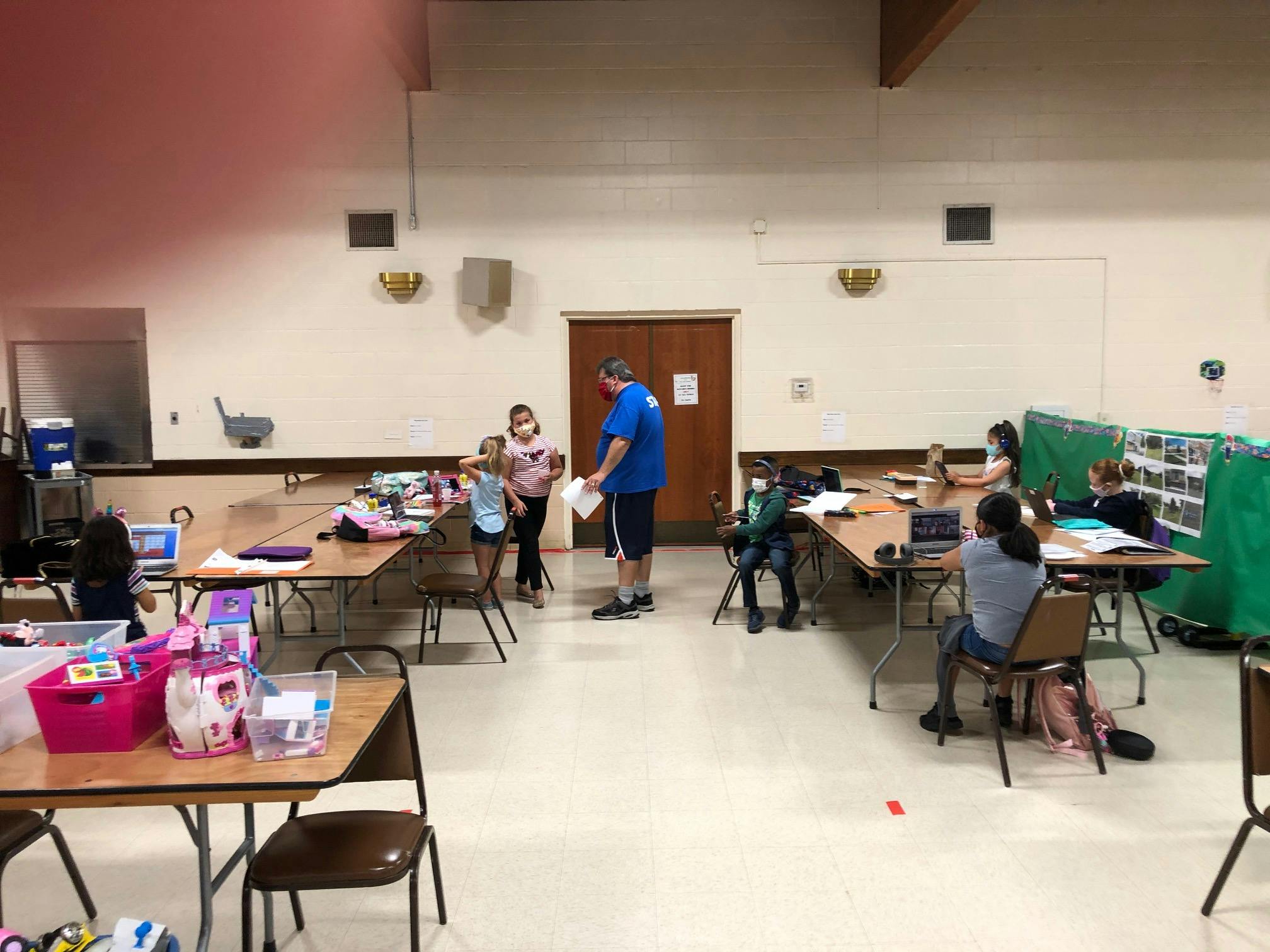 Adult and children in a large room with tables