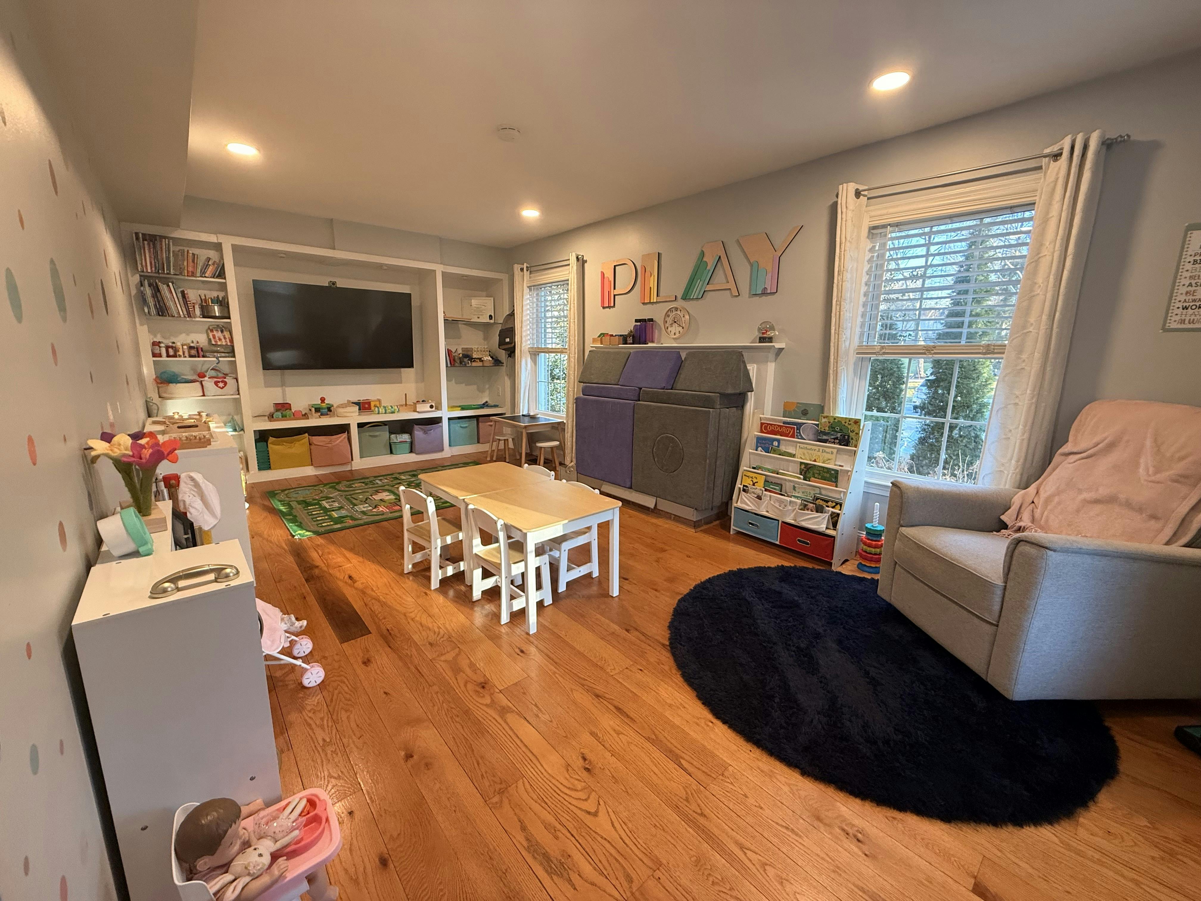 Playroom with a table and chairs, a large TV, and toy storage