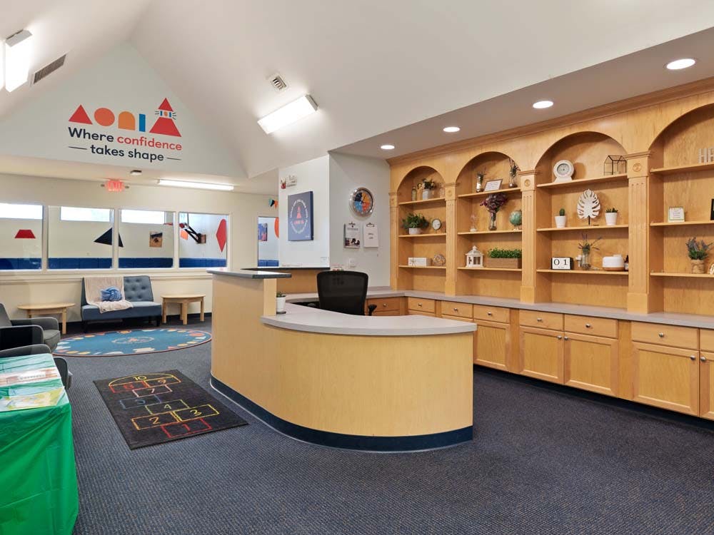 Reception desk in an educational building with wood shelving and seating