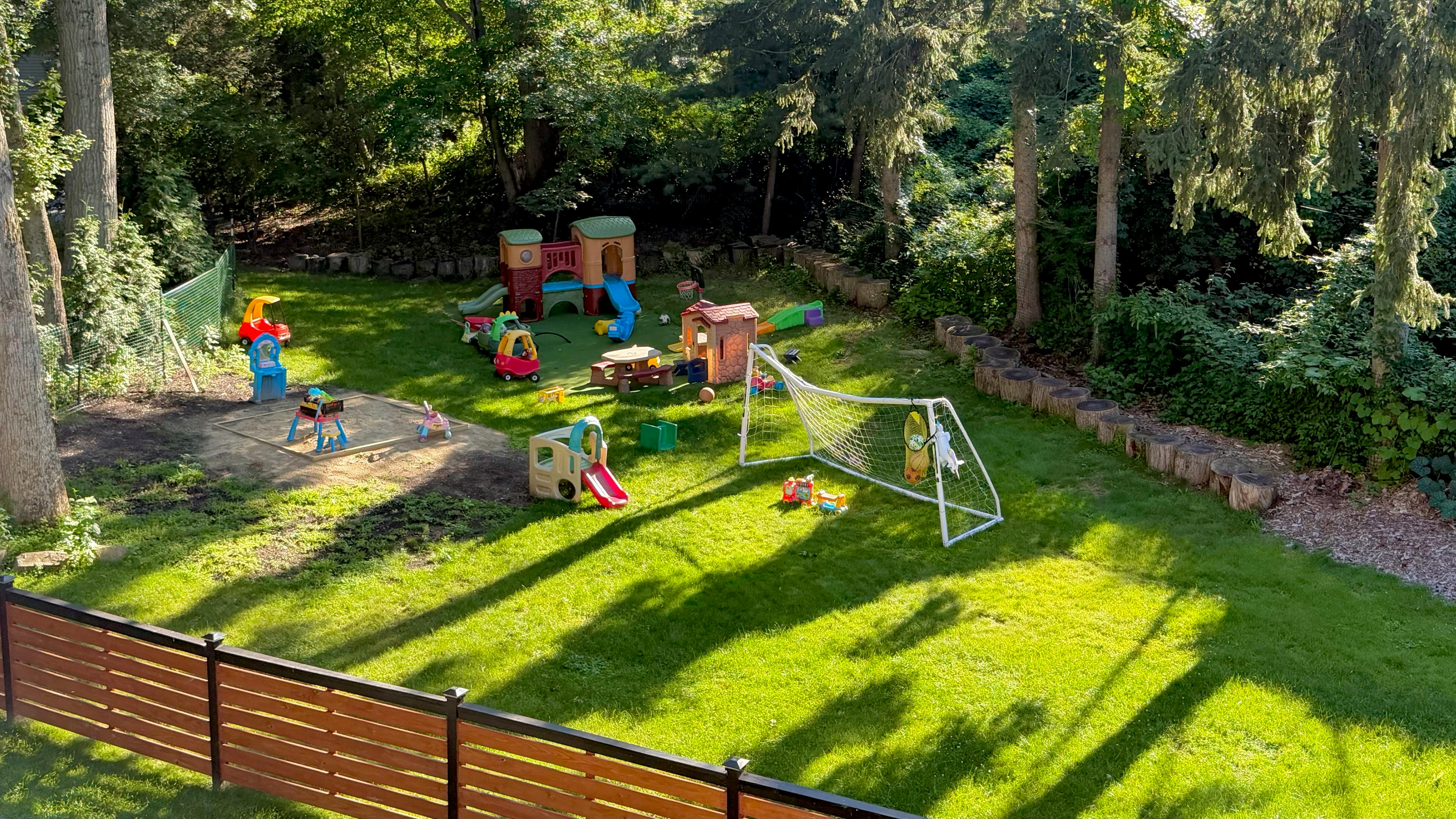Backyard playground with toys, play structures, and a soccer goal