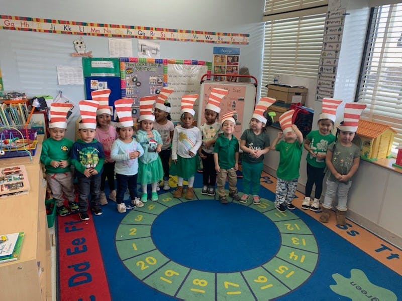 Children wearing striped hats standing in a classroom