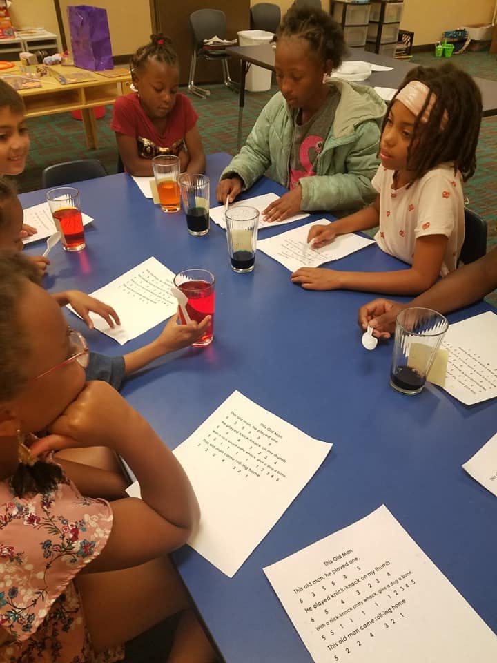 People and children sitting at a table with papers and glasses