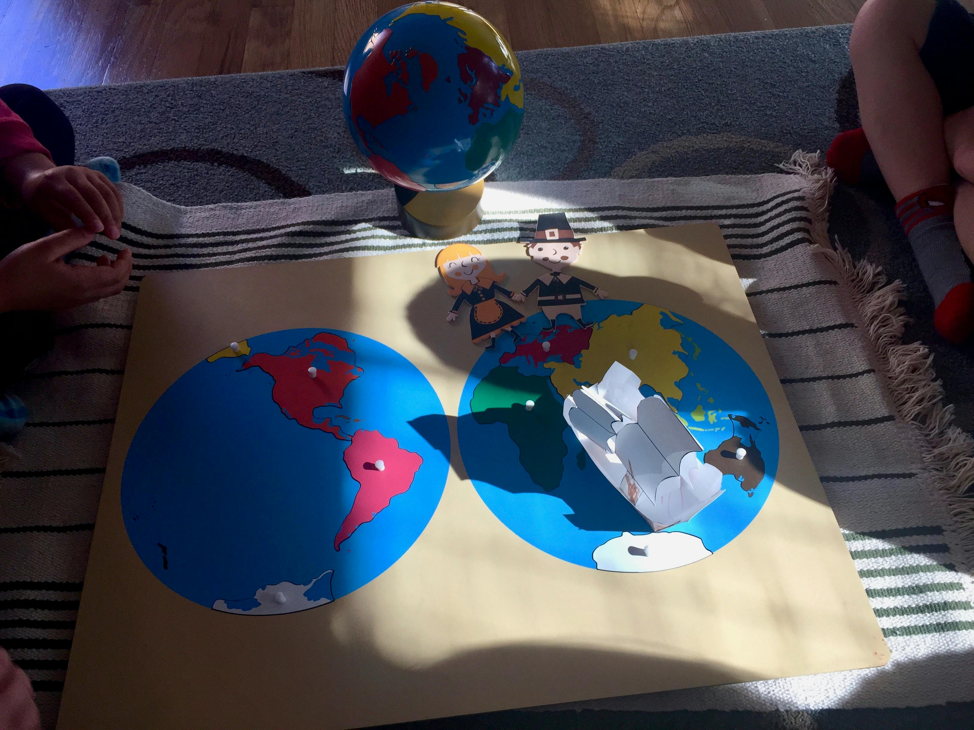 Two round maps of the world and a globe on a rug