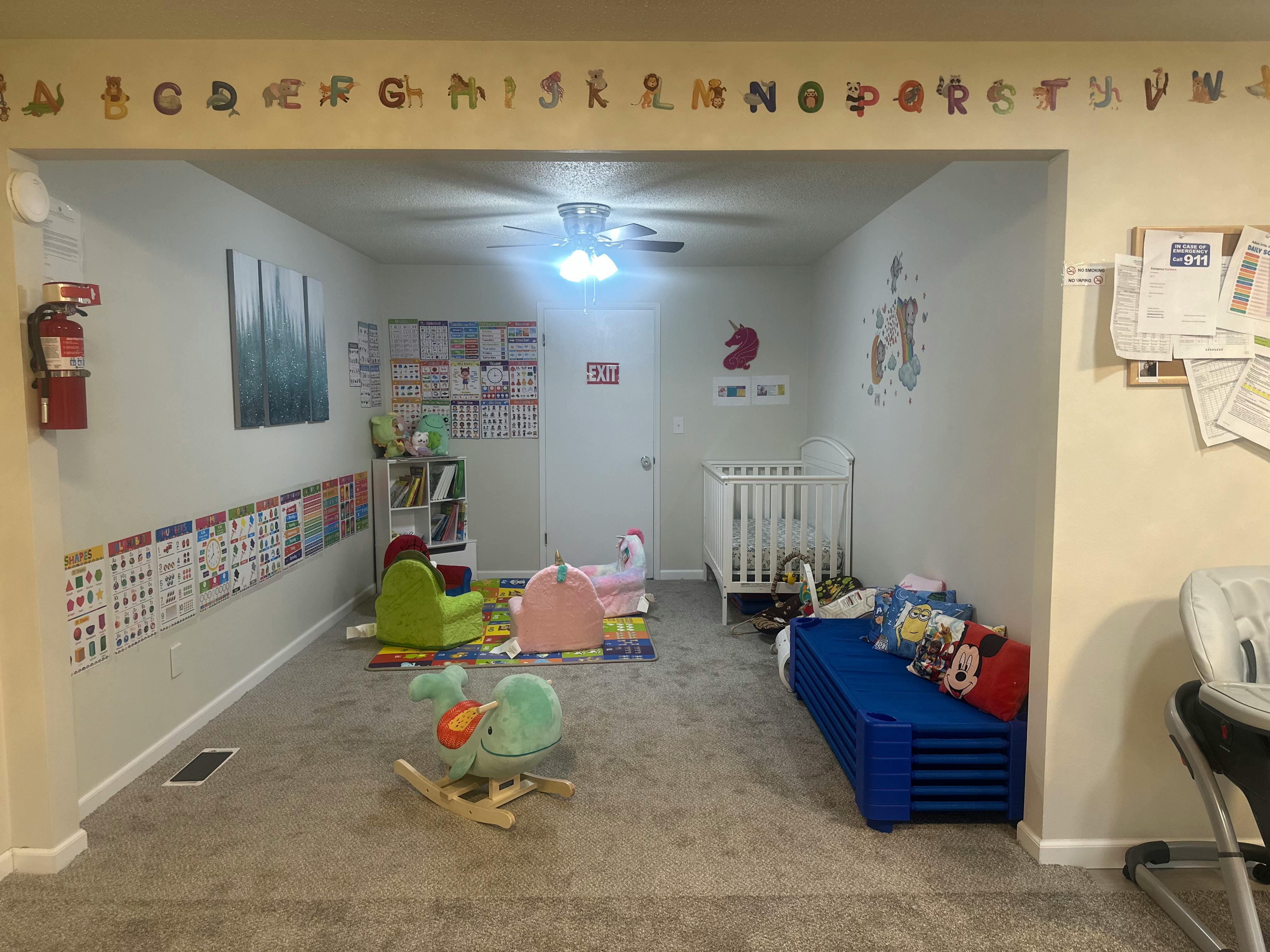 Playroom with crib, small chairs, and toys