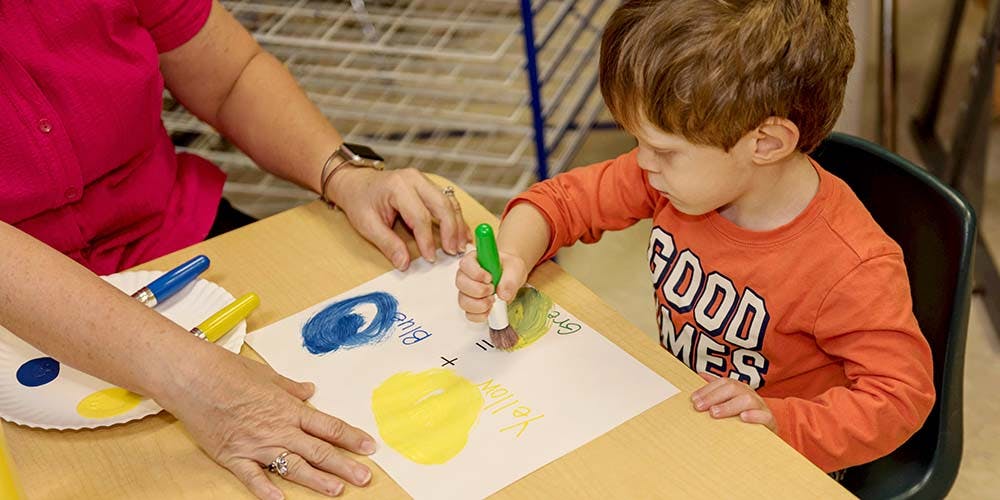 Adult and child painting together at a table