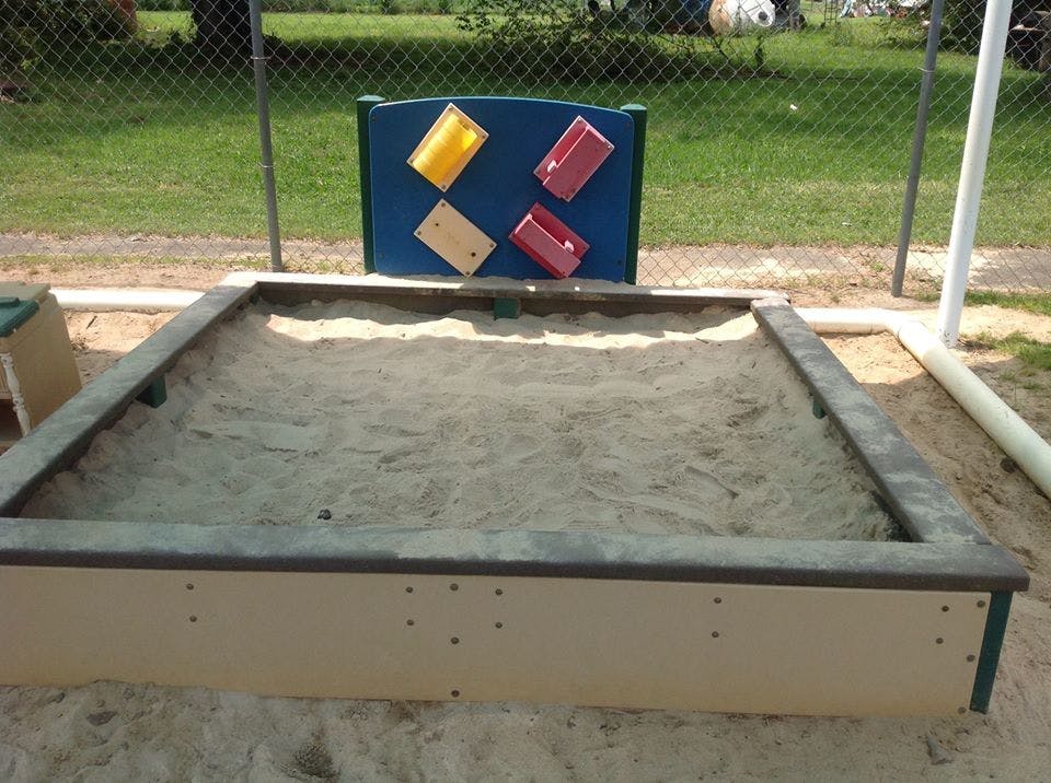 Empty sandbox with a blue toy panel