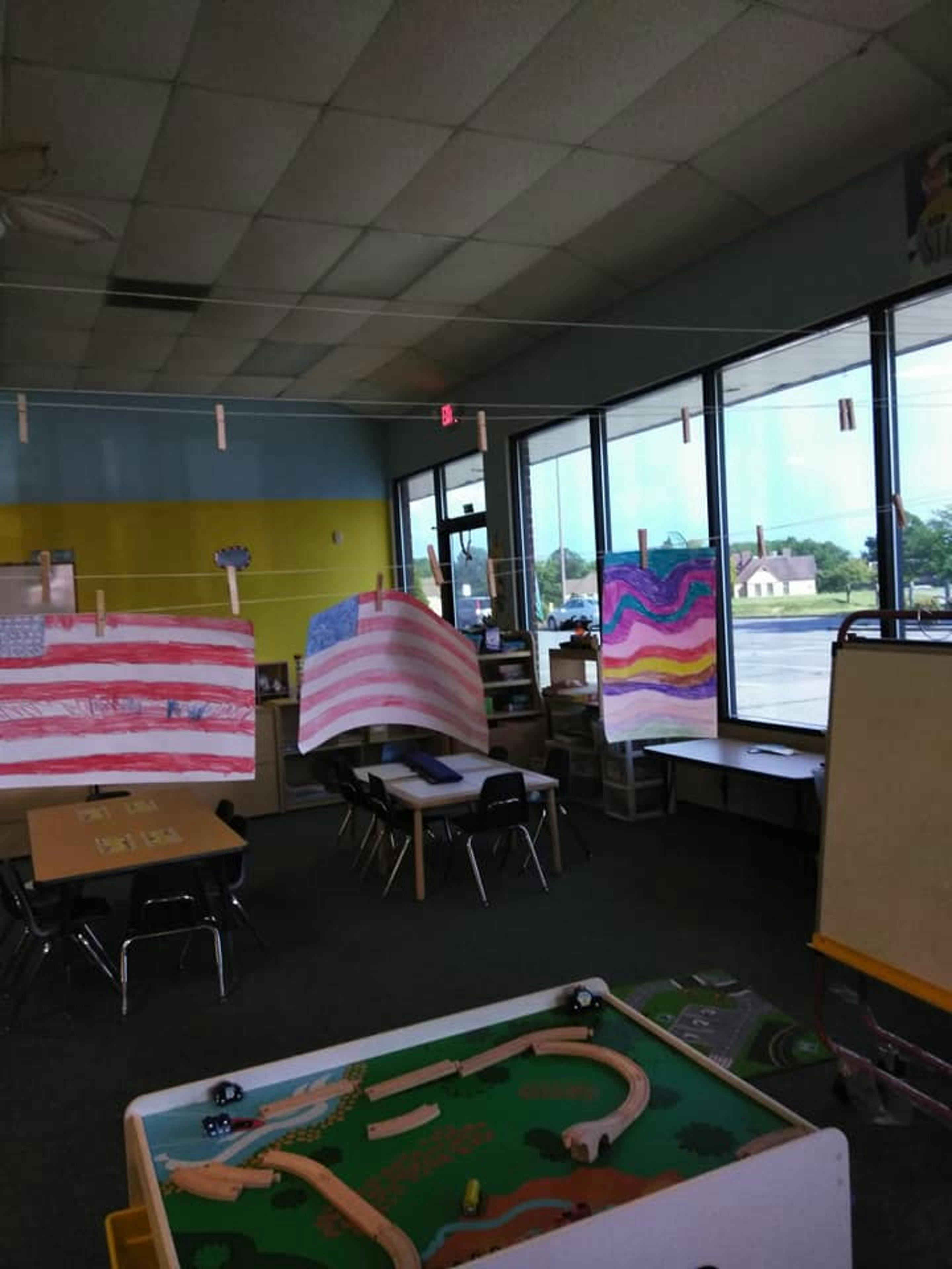 Classroom with children's artwork of American flags and a colorful abstract painting
