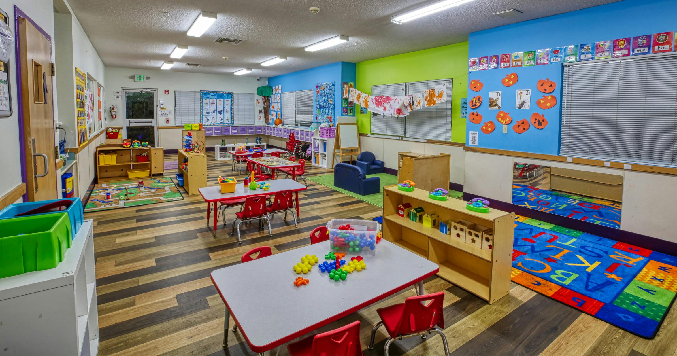 An empty early childhood classroom with colorful walls and children's furniture