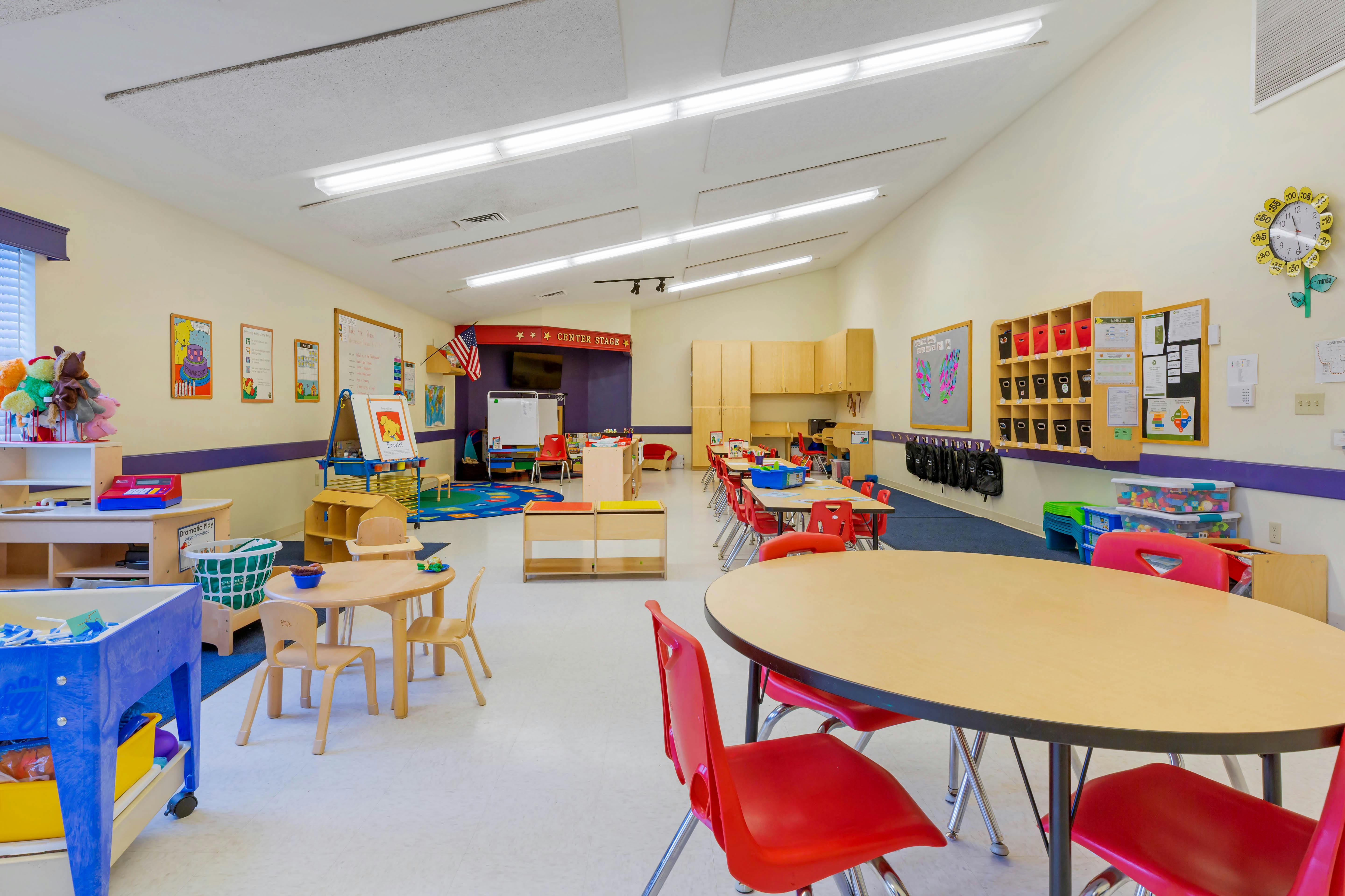 Classroom with tables, chairs, teaching materials, and a "Center Stage" sign