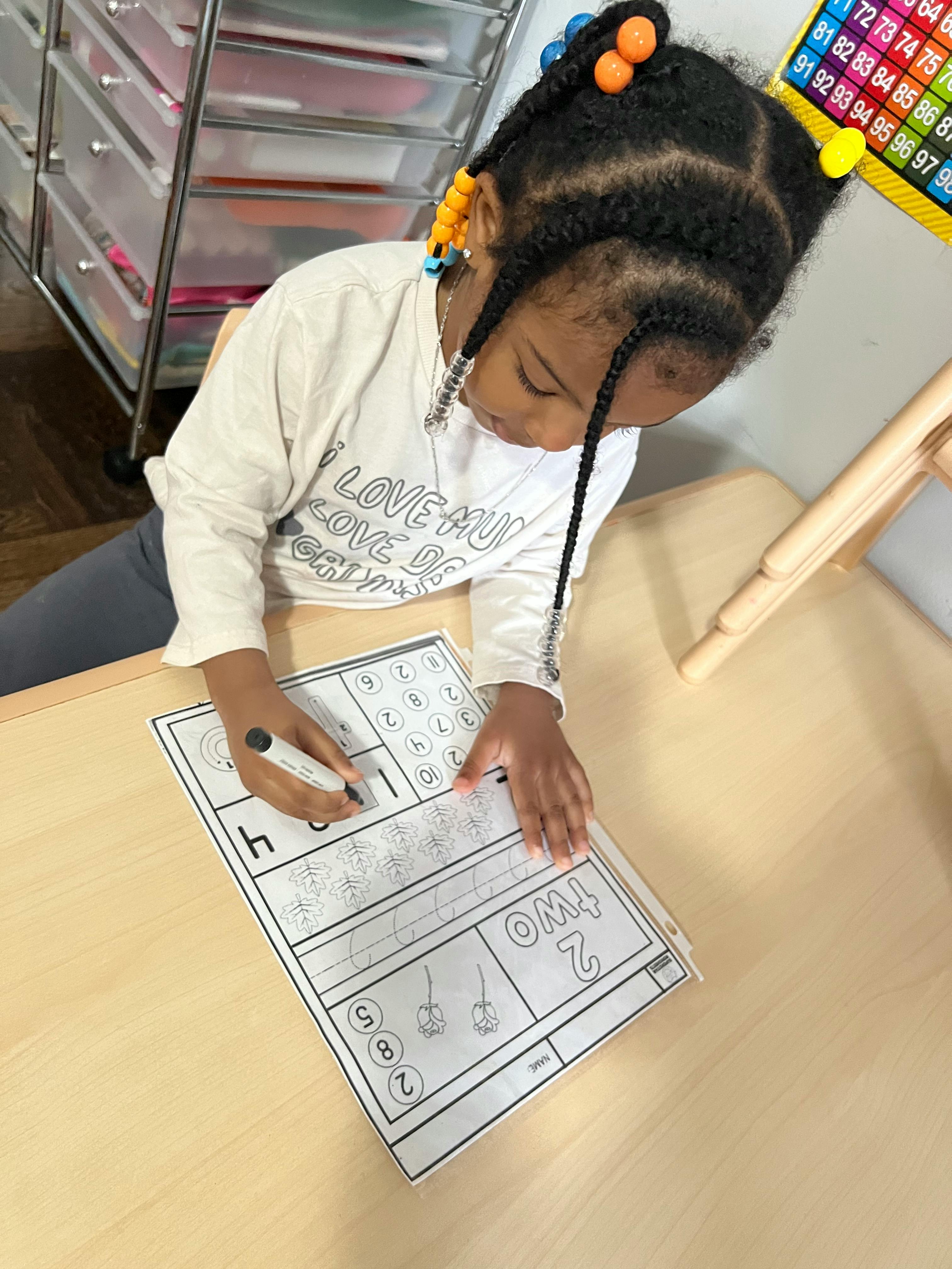 Child writing on a worksheet at a table