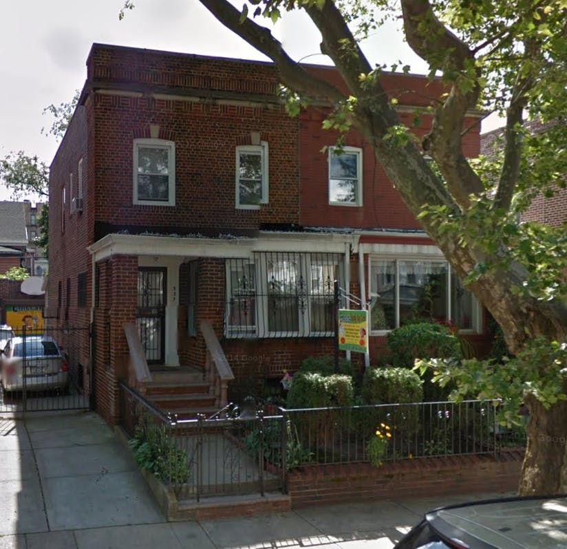 Red brick house with a small front yard and a tree