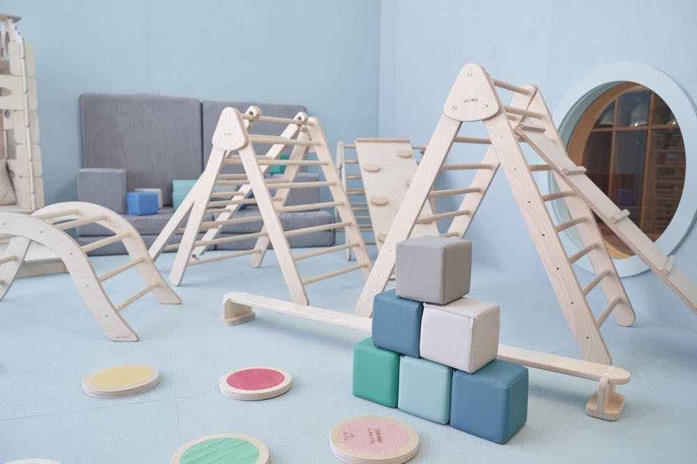 Wooden climbing structures and soft play blocks in a room