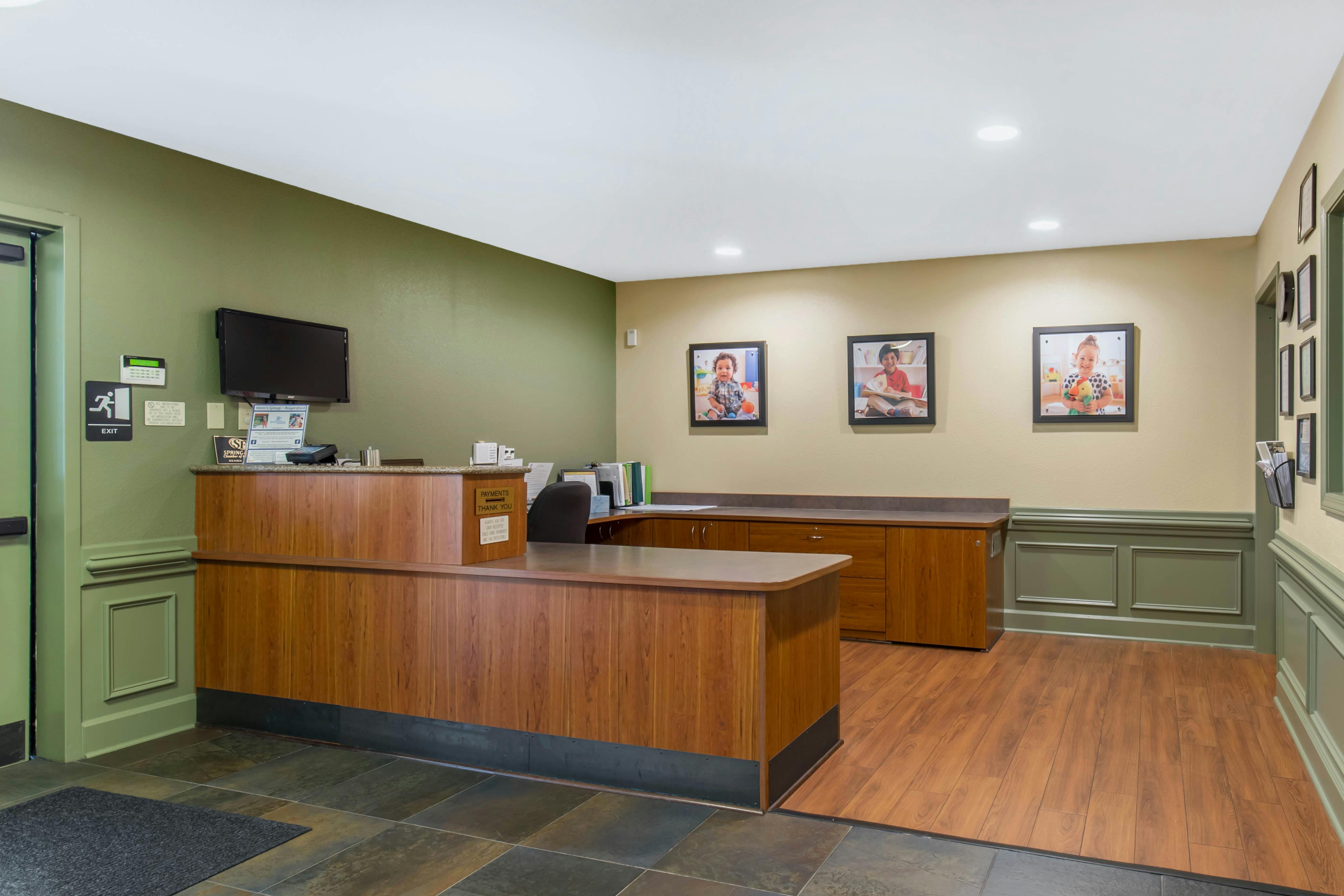 Reception area with a wooden desk and three framed pictures on the wall