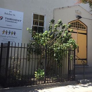 Building exterior with a sign for Thrivent Financial and a black fence