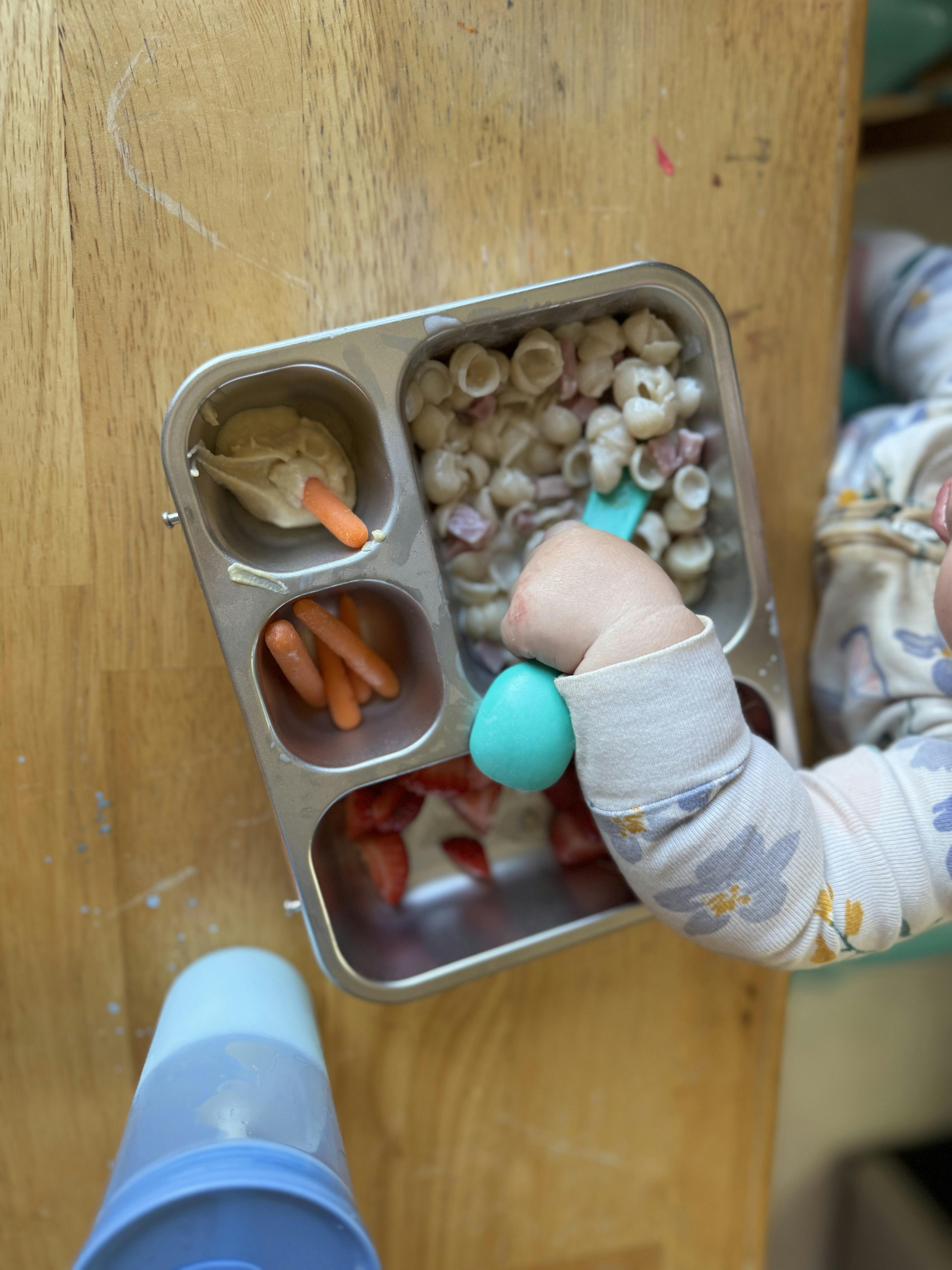 Child eating from a divided metal food tray