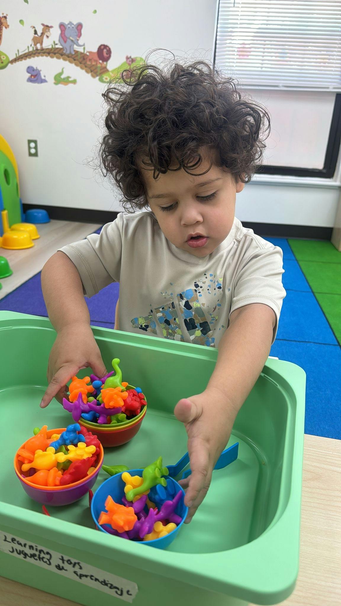 Child playing with colorful dinosaur counting toys