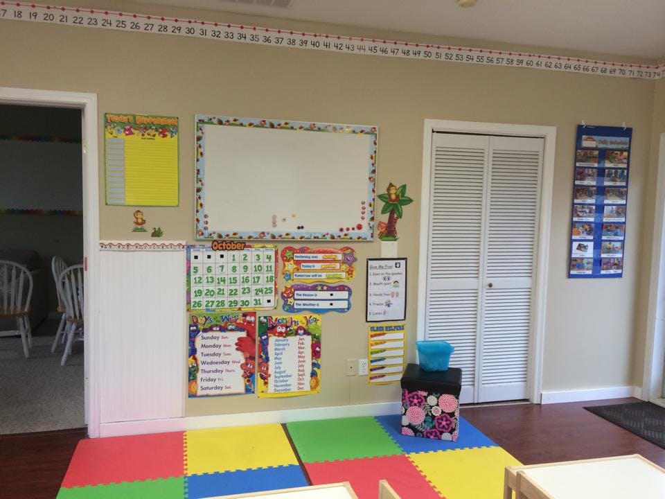 Classroom wall with whiteboard, calendar, and colorful floor mats