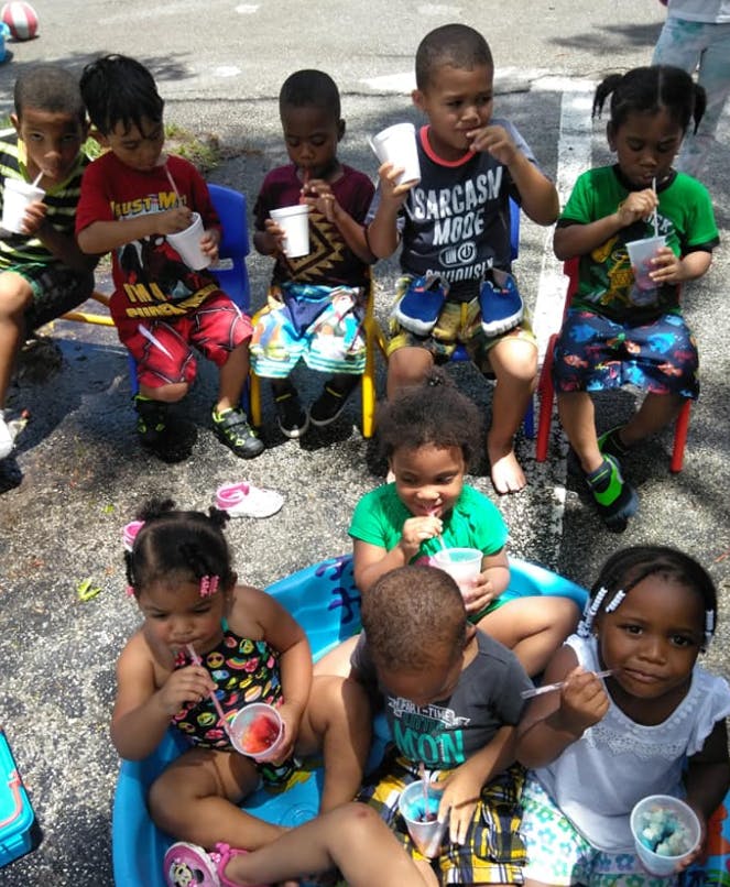 Group of children drinking from cups with straws