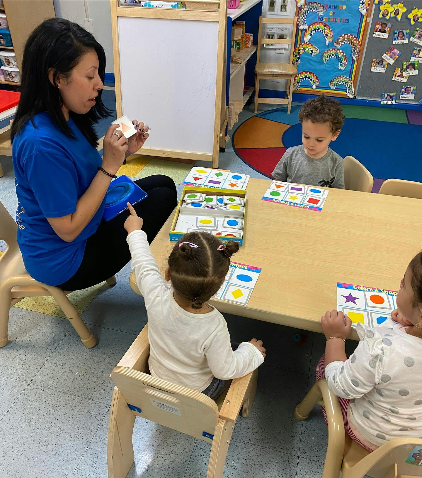 Person teaching children at a table in a classroom
