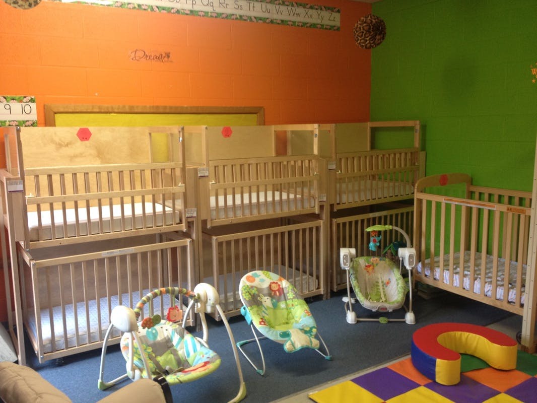 Multiple cribs and baby bouncers in a room