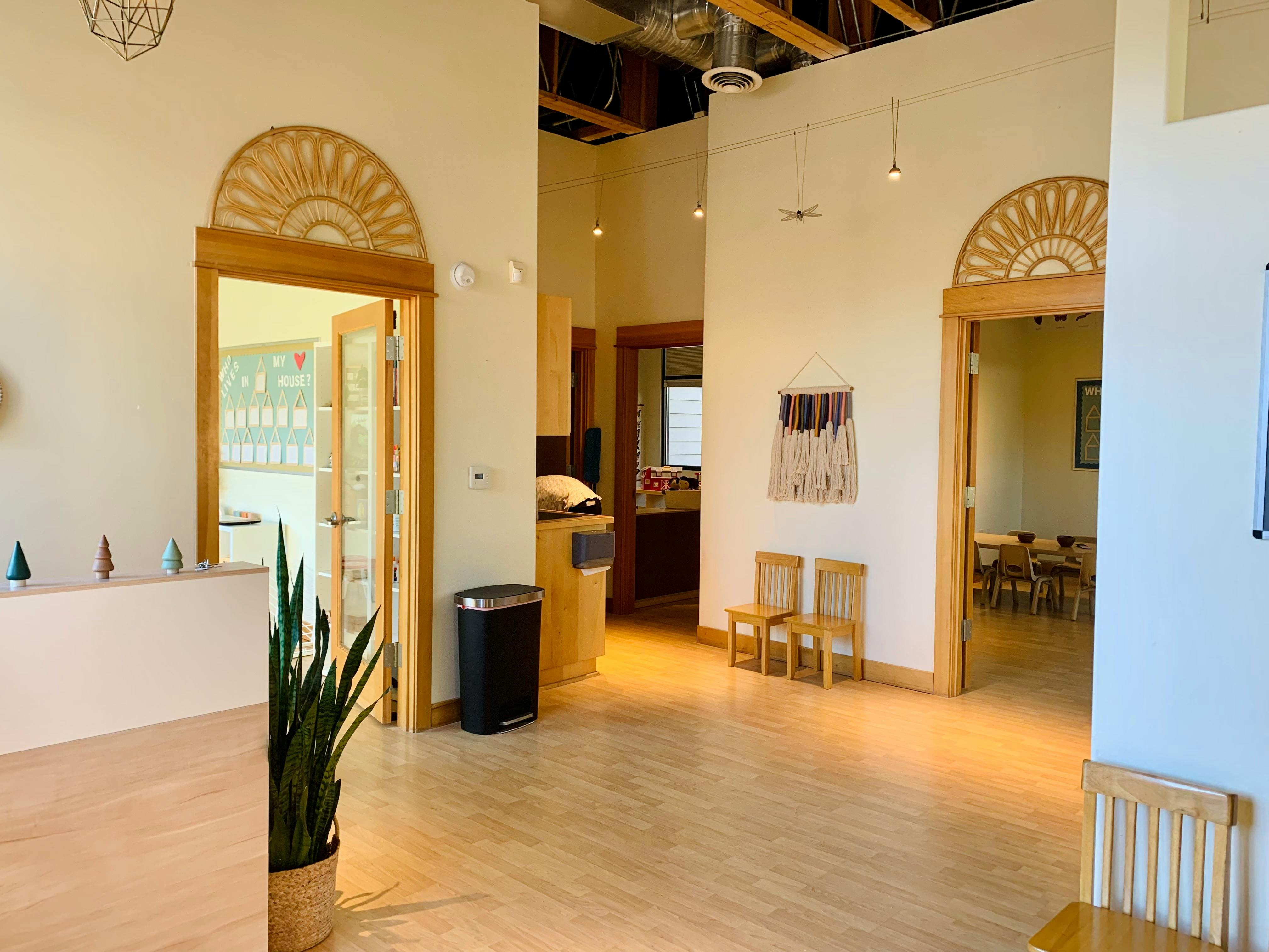 Interior view of a building with multiple doorways and light wood floors