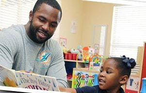 Adult and child reading a book together