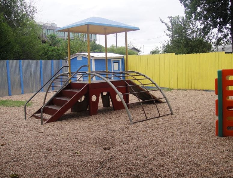 Playground structure with stairs and climbing arch on wood chips
