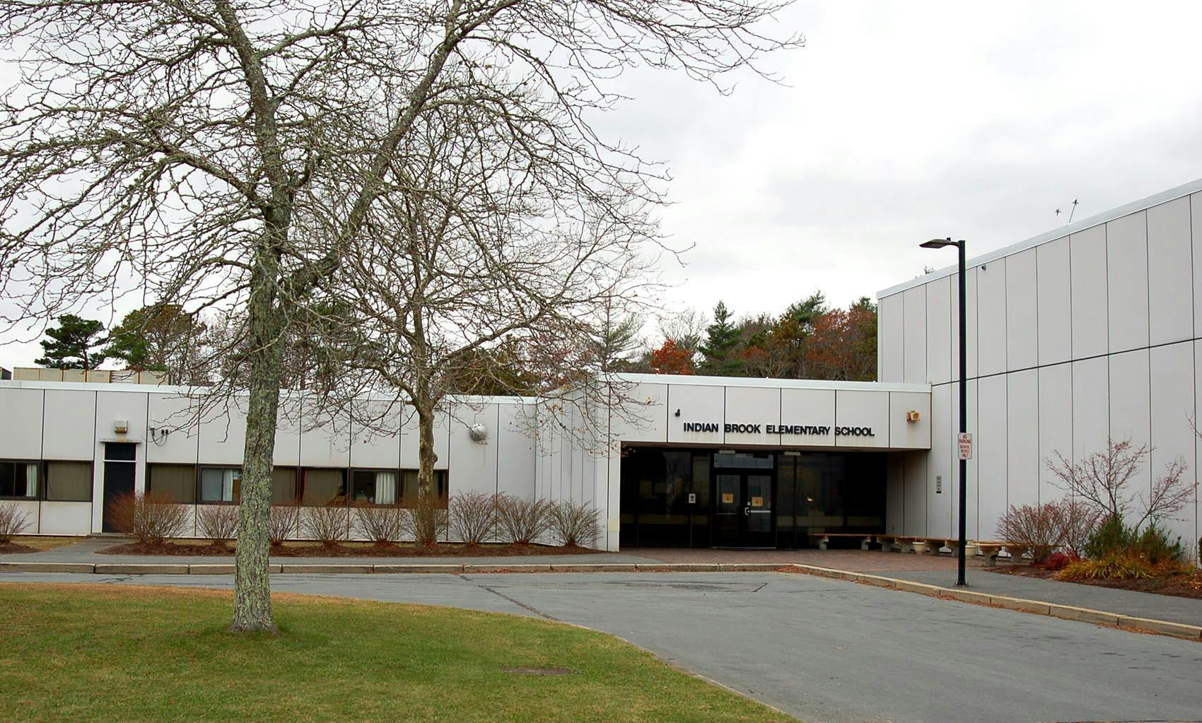 Front exterior of a school building with a tree in the foreground