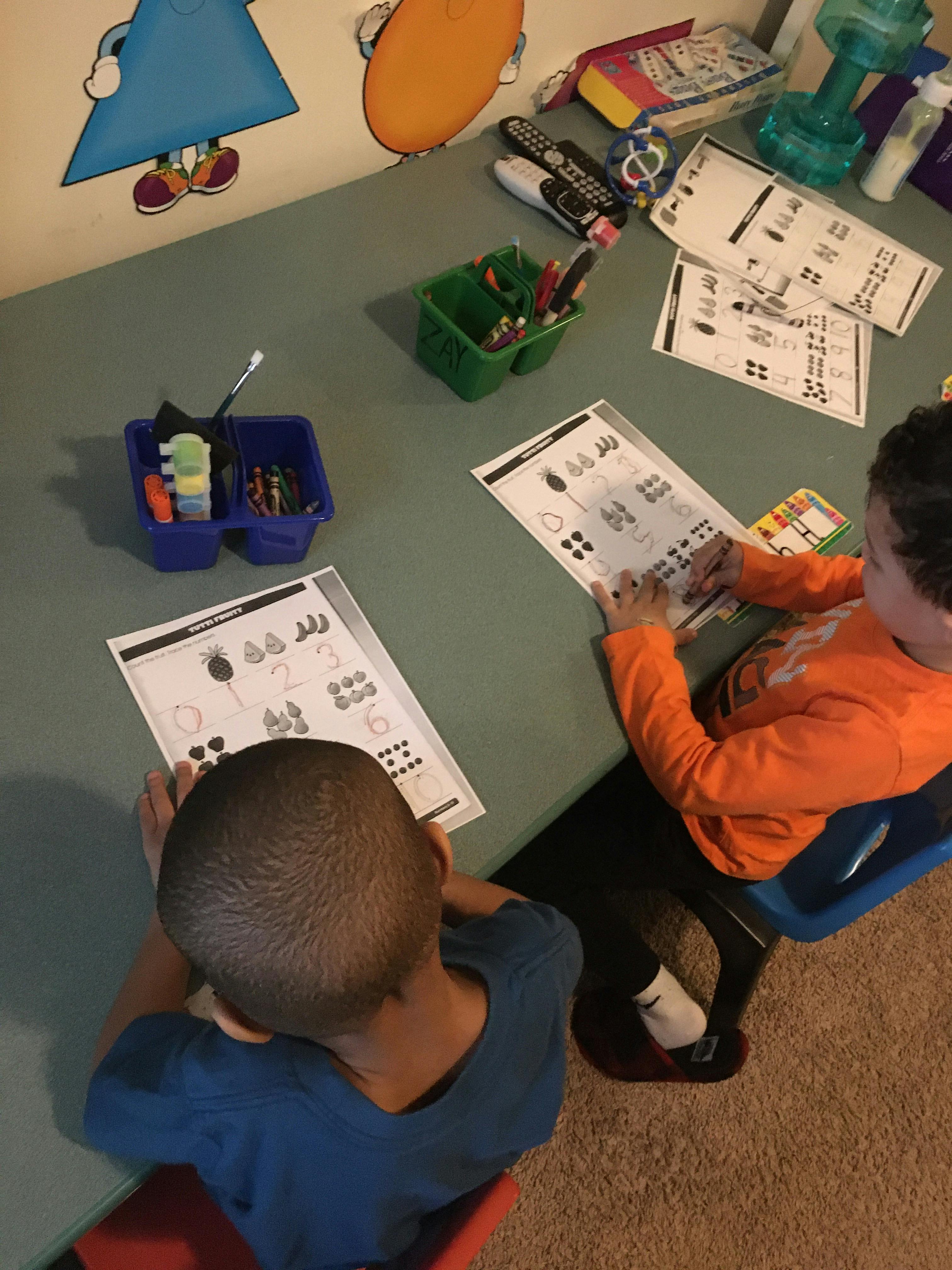 Two children sitting at a table doing schoolwork