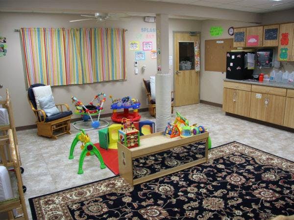 Playroom with various toys, a rocking chair, and a kitchen area
