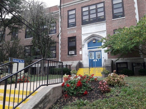 Brick building with blue double doors and yellow steps