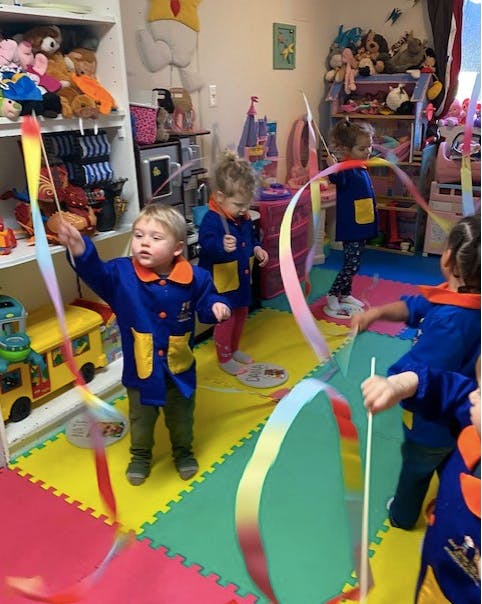 Children playing with colorful ribbons in a classroom