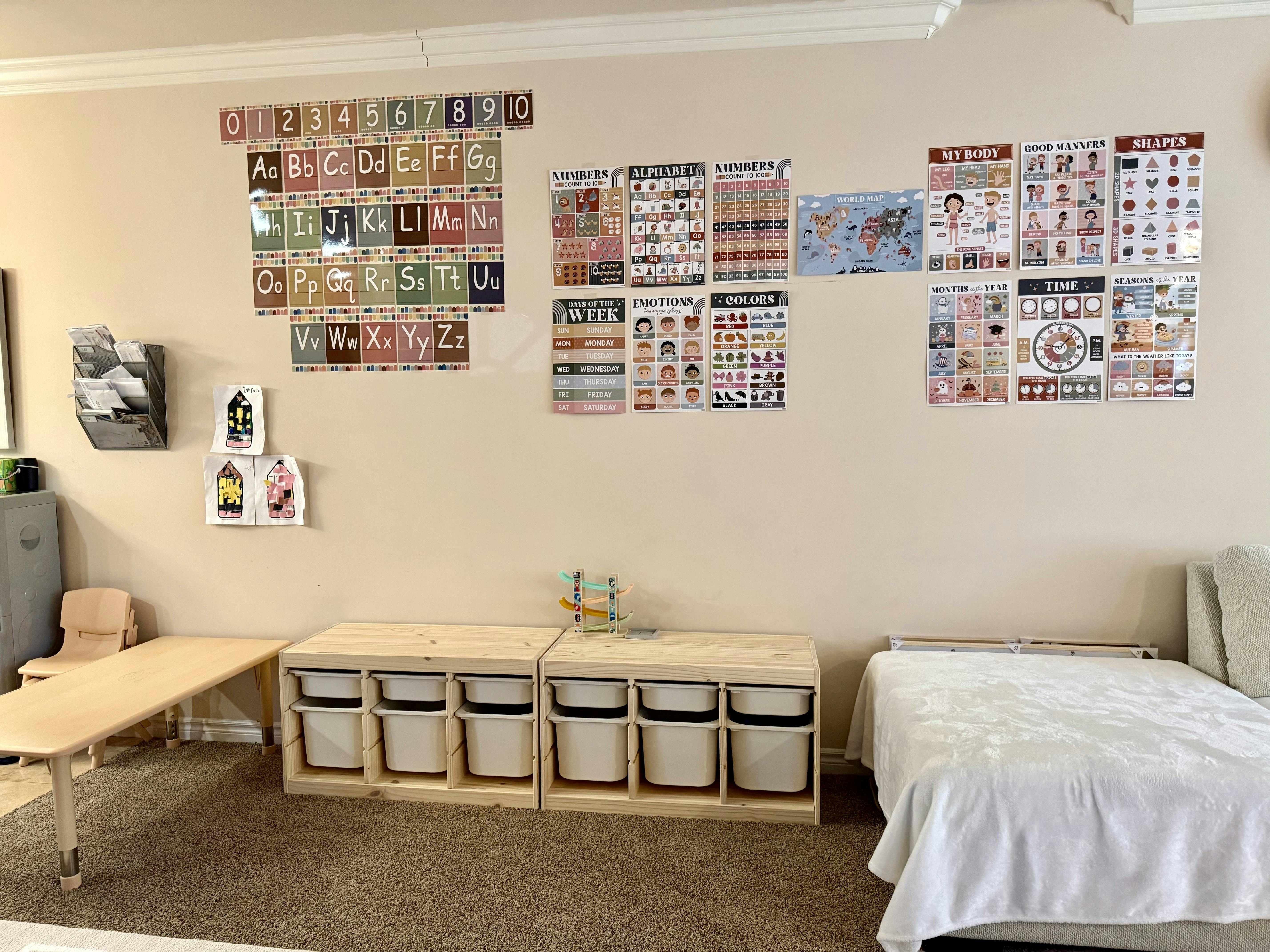 Educational wall posters in a playroom with storage bins and a low table