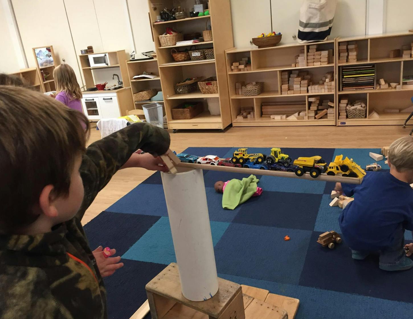 Child playing with a cardboard tube in a classroom