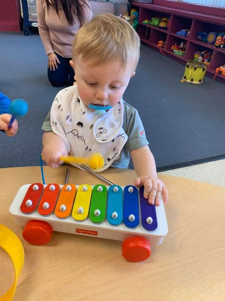 Child playing a colorful toy xylophone