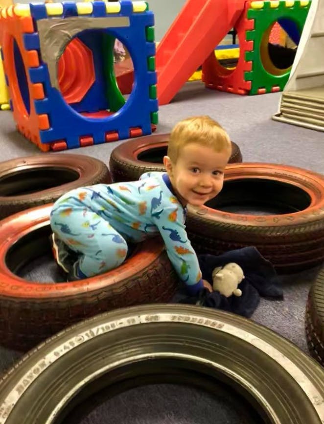 Child crawling through tires on a playground