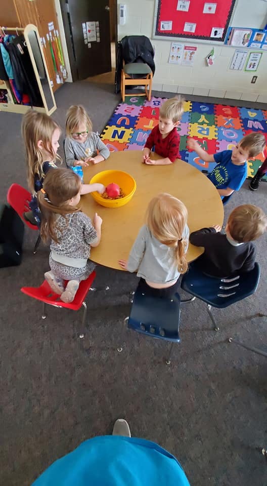 Children sitting around a table in a classroom