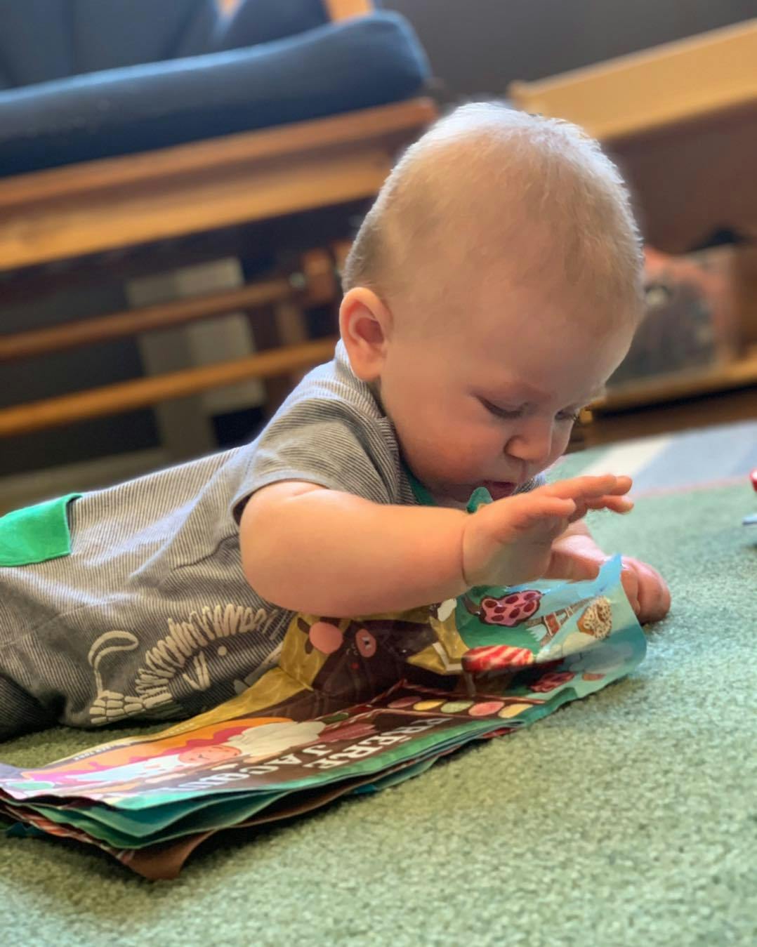 Child on stomach looking at a book