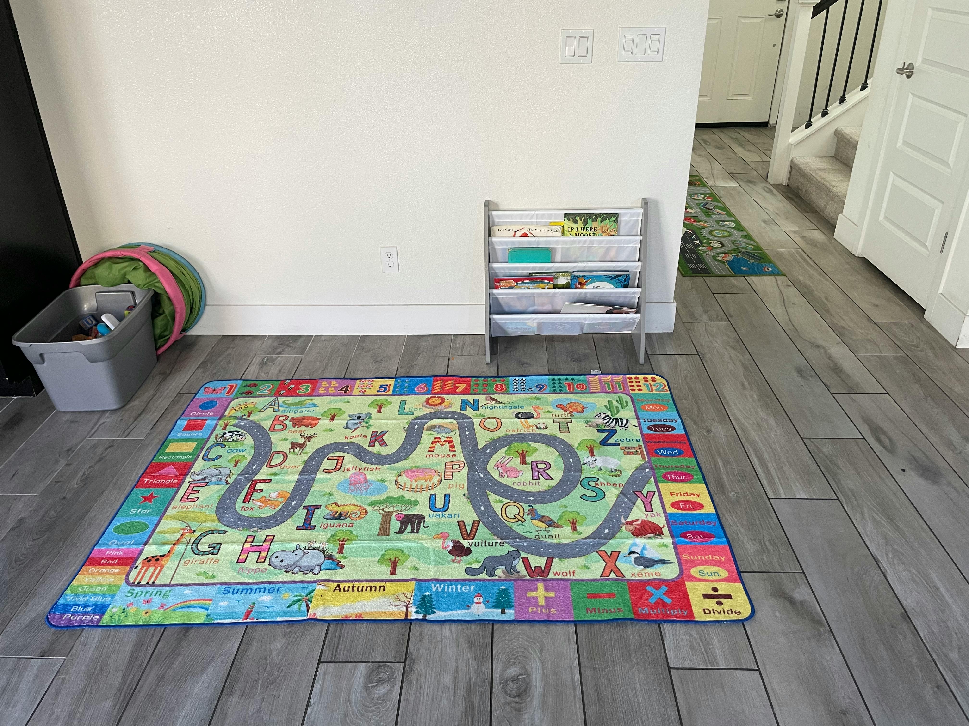 Playmat with roads and letters on a wooden floor