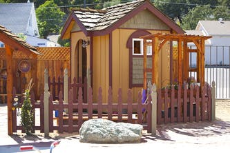Small wooden playhouse with a fence