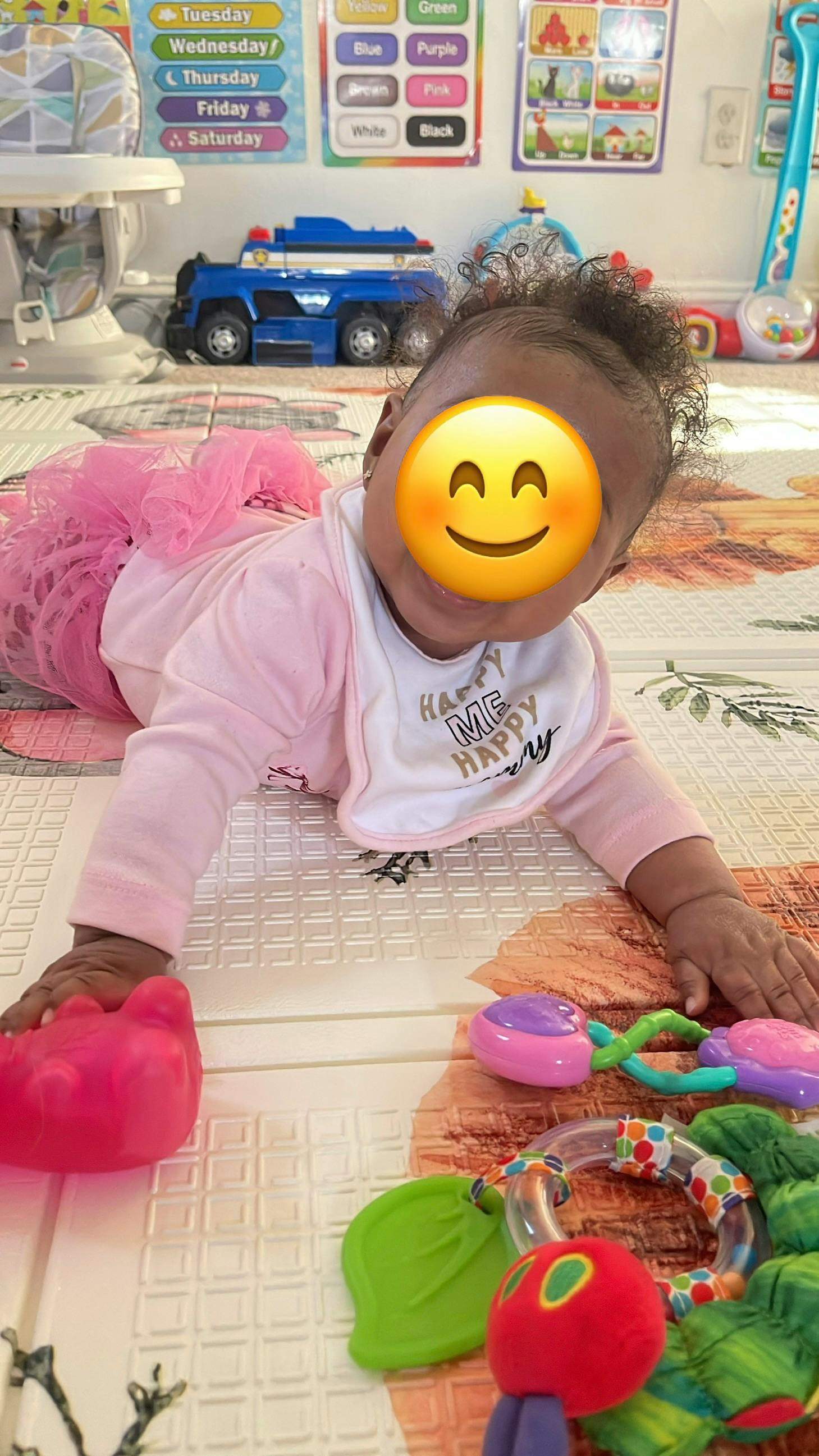 Child lying on a play mat with toys