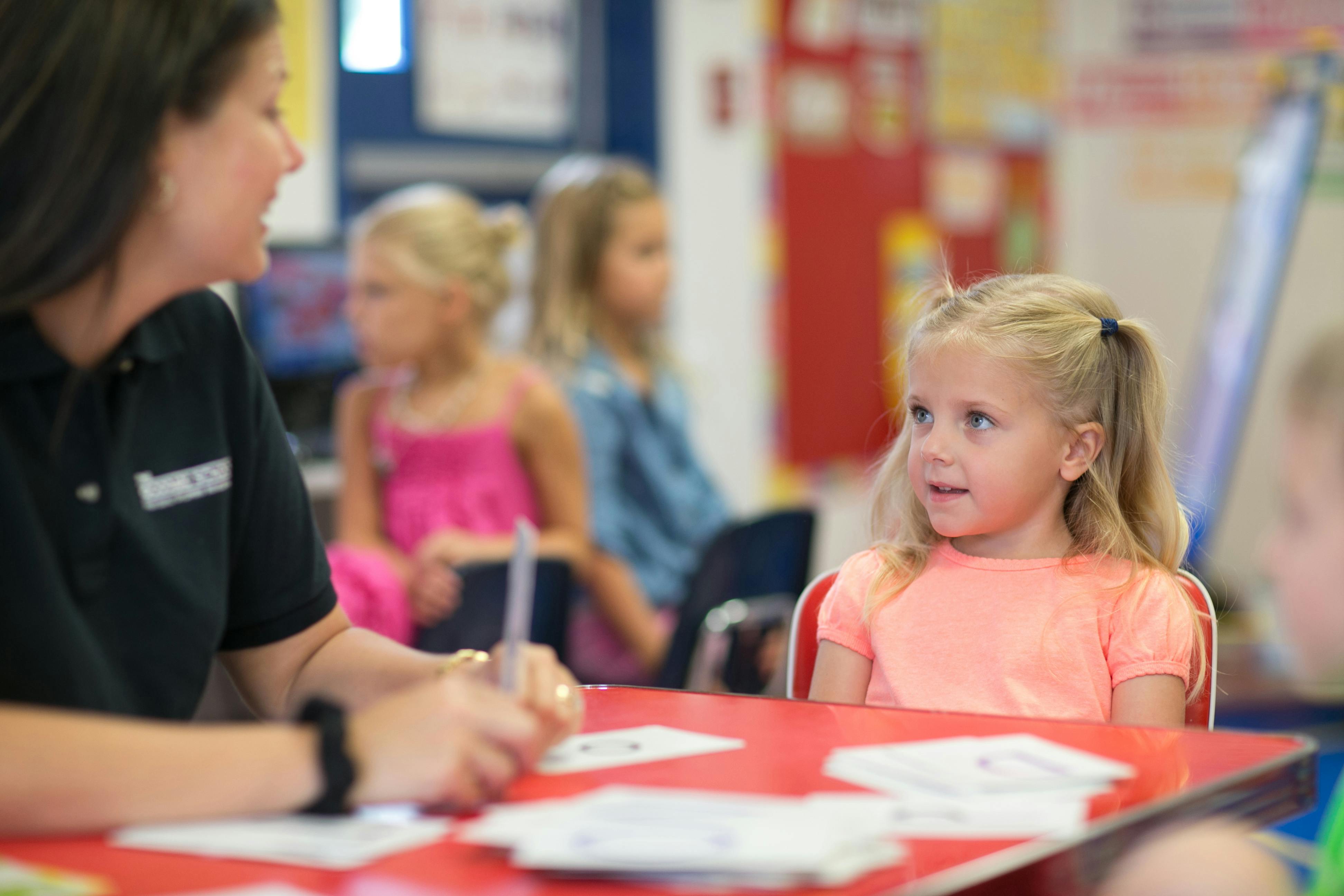 Person and child at a table in a classroom