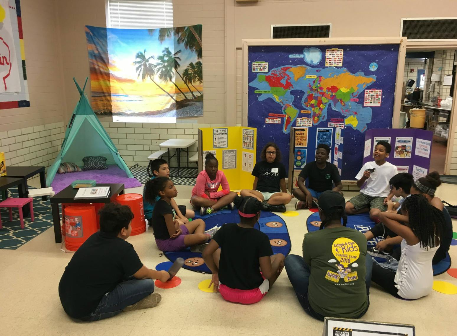 Group of teens and adults sitting in a circle on the floor